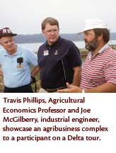 Travis Phillips, Agricultural Economics professor and Joe McGilberry, industrial engineer, showcase an agribusiness complex to a participant on a Delta tour.